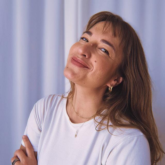 Portrait of Aleksandra Grechuta, smiling, in a white T-shirt